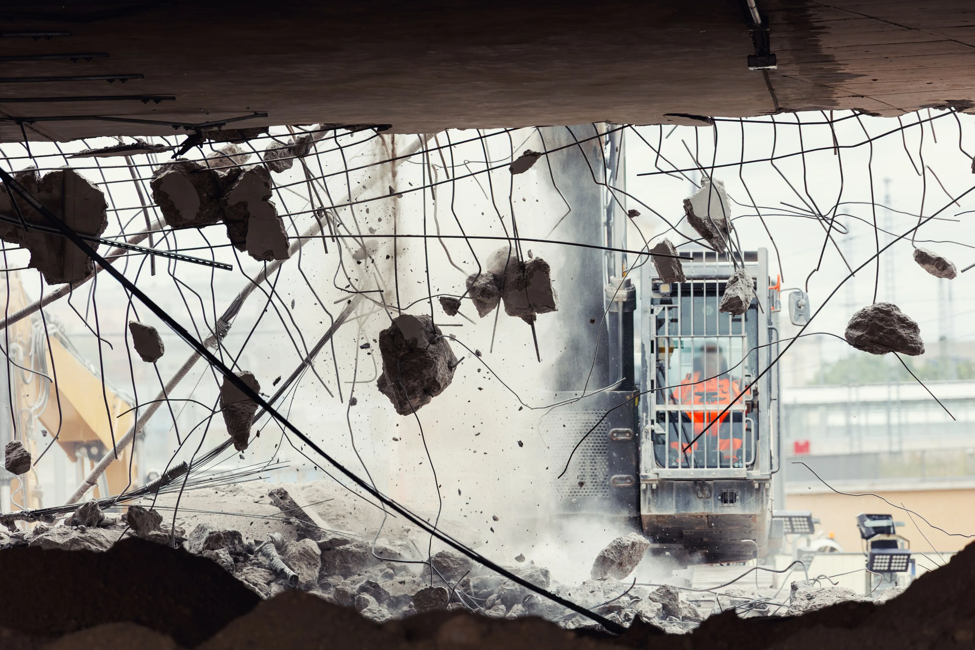 Industrial demolition machinery dismantling a large-scale concrete and steel structure for a commercial redevelopment project in Dallas.